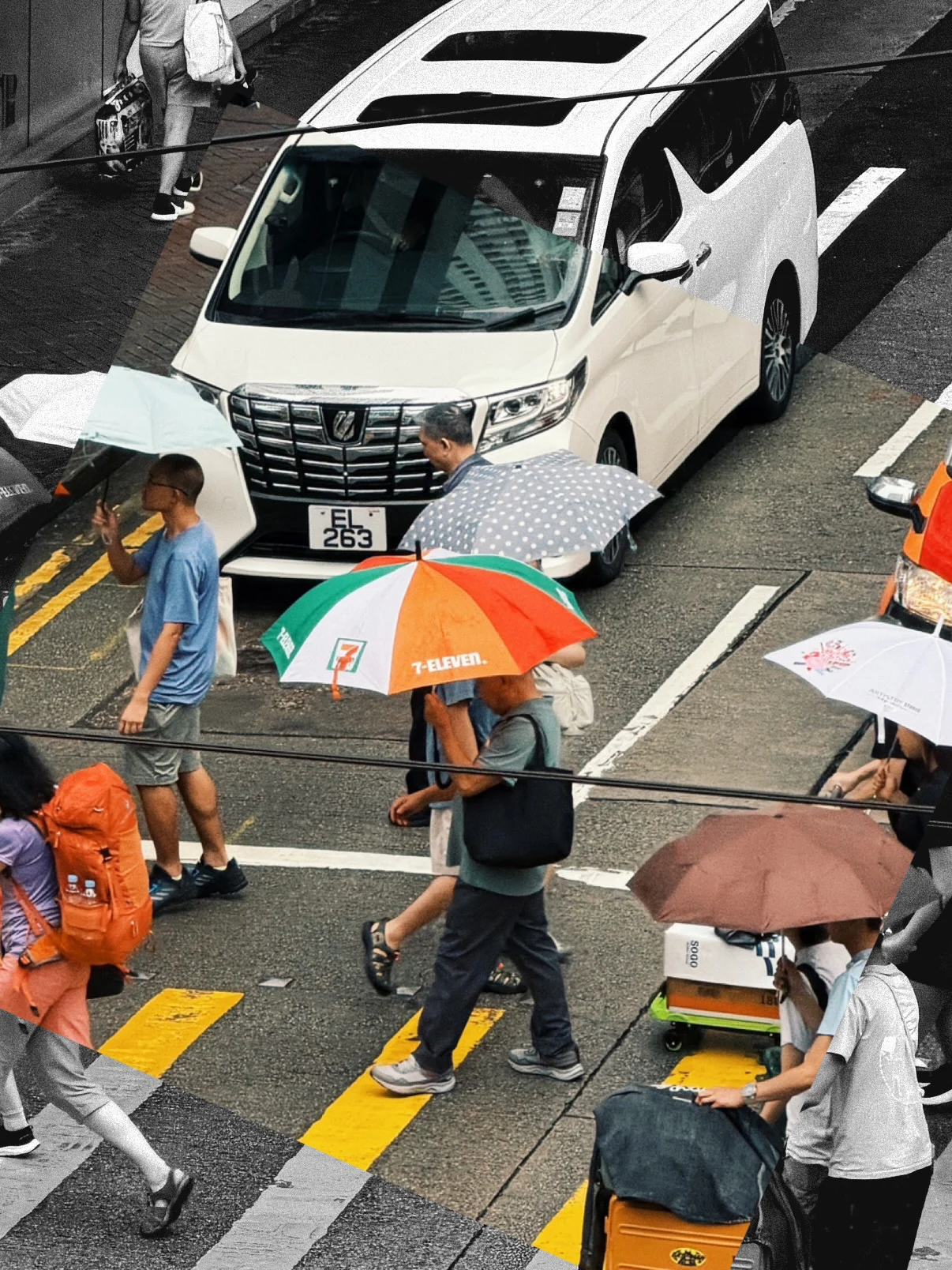 People with umbrellas crossing a road in front of a white van, seen from above